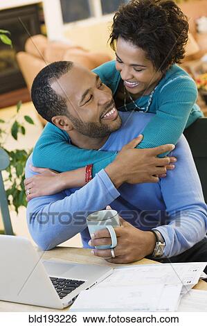 Stock Photograph - African American husband hugging wife. Fotosearch