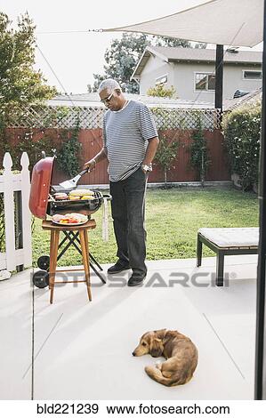 African American man grilling in backyard View Large Photo Image Stock Photo - African American man grilling in backyard. Fotosearch