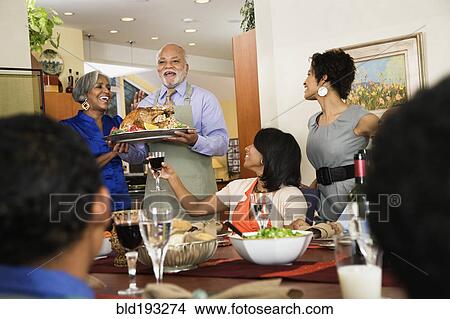 Picture - African American man serving Thanksgiving turkey. Fotosearch