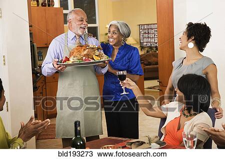 Stock Image - African American man serving Thanksgiving turkey. Fotosearch