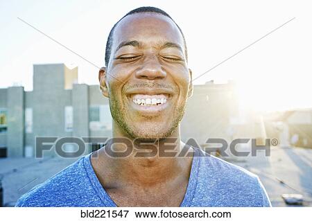 Stock Photo - African American man smiling outdoors. Fotosearch