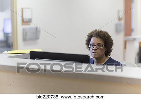 Stock Photography - African American nurse using computer in hospital. Fotosearch