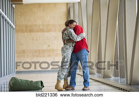 Stock Photograph - African American soldier hugging husband in airport. Fotosearch