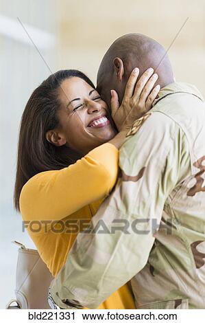 Stock Image - African American soldier hugging wife. Fotosearch