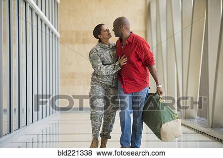 Stock Photo - African American soldier talking to husband in airport. Fotosearch