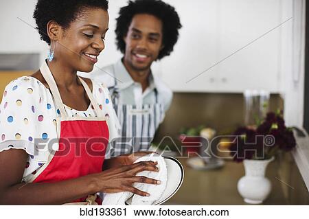 Stock Image - African American woman washing dishes. Fotosearch