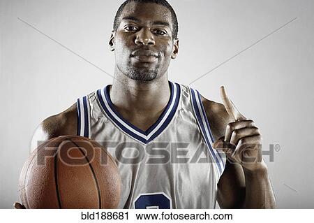 Stock Image - African basketball player holding basketball. Fotosearch