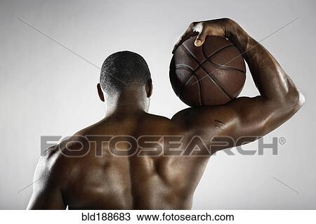 Stock Image - African basketball player holding basketball. Fotosearch