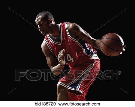Stock Image - African basketball player holding basketball. Fotosearch