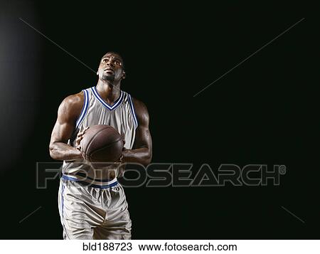 Stock Image - African basketball player holding basketball. Fotosearch