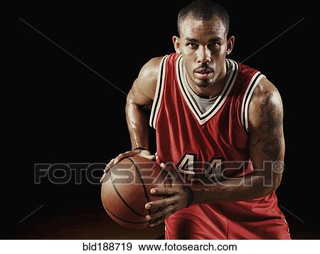 Stock Photo - African basketball player holding basketball. Fotosearch