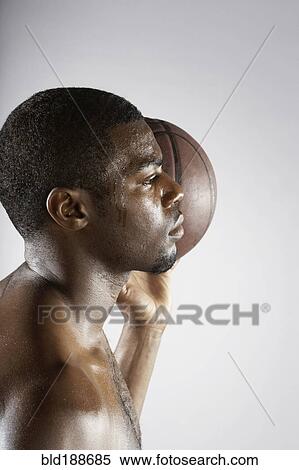 Stock Photography - African basketball player holding basketball. Fotosearch