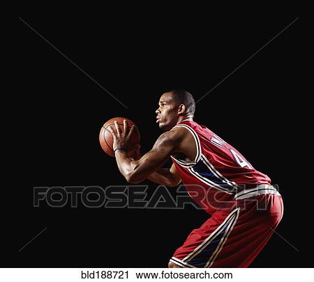 Stock Image - African basketball player shooting basketball. Fotosearch