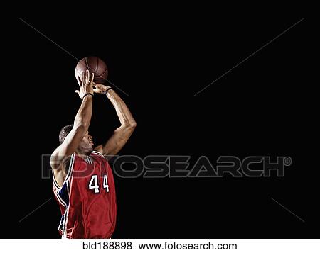 Stock Photo - African basketball player shooting basketball. Fotosearch