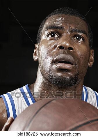 Stock Photography - African basketball player shooting basketball. Fotosearch