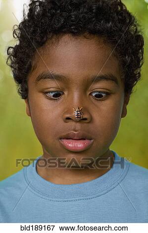 African boy with insect on his nose View Large Photo Image Stock Photo - African boy with insect on his nose. Fotosearch
