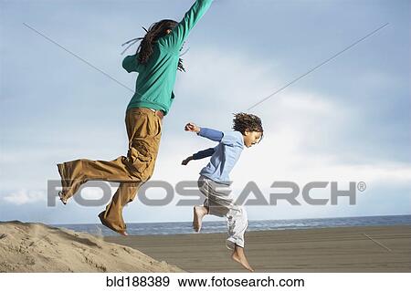 African brothers jumping on sand dune View Large Photo Image Stock Photo - African brothers jumping on sand dune. Fotosearch