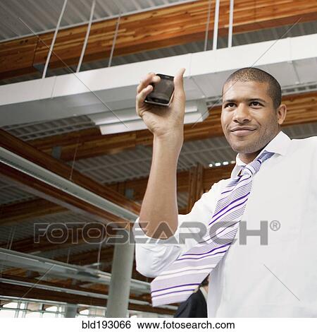 African businessman holding cell phone View Large Photo Image Stock Photograph - African businessman holding cell phone. Fotosearch