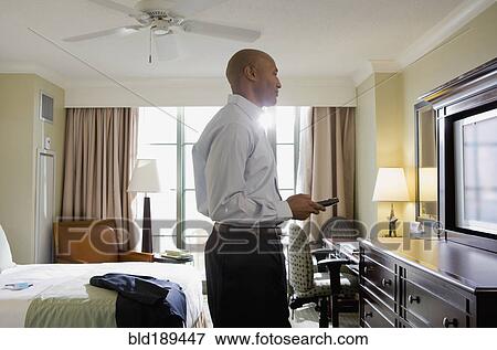 African businessman in hotel watching television View Large Photo Image Stock Photo - African businessman in hotel watching television. Fotosearch