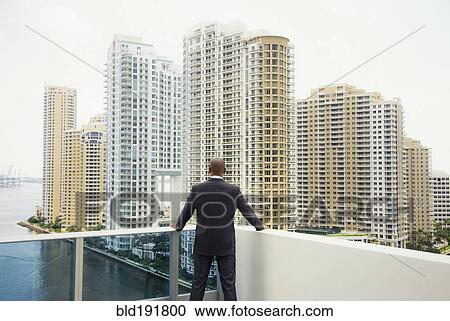 African businessman looking at city from urban balcony View Large Photo Image Stock Image - African businessman looking at city from urban balcony. Fotosearch
