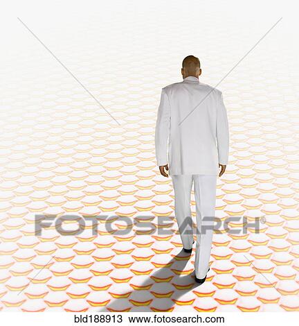 Stock Image - African businessman walking in surreal setting. Fotosearch