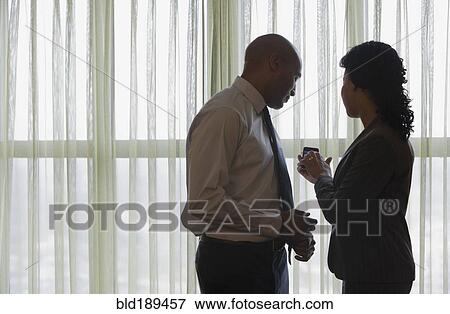 Stock Photo - African businesspeople looking at cell phone. Fotosearch