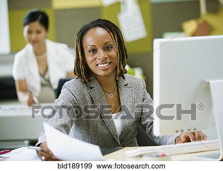 Stock Photo - African businesswoman working at desk. Fotosearch
