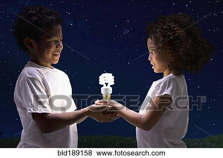 African children holding glowing cfl lightbulb View Large Photo Image Stock Photo - African children holding glowing cfl lightbulb. Fotosearch
