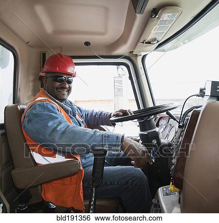 Stock Photograph - African construction worker driving truck. Fotosearch