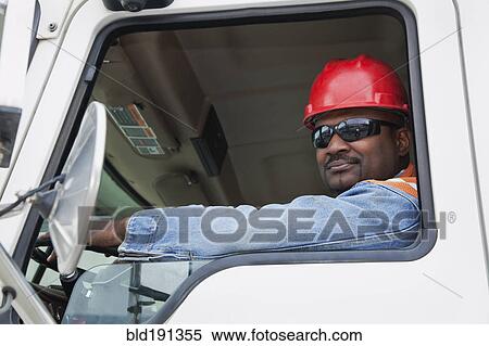 Stock Photography - African construction worker driving truck. Fotosearch