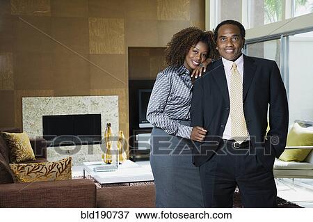 Stock Photo - African couple standing in modern living room. Fotosearch