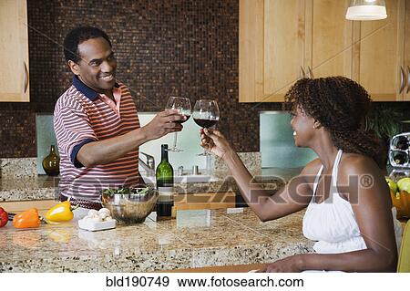 African couple toasting with red wine in kitchen View Large Photo Image Stock Photo - African couple toasting with red wine in kitchen. Fotosearch
