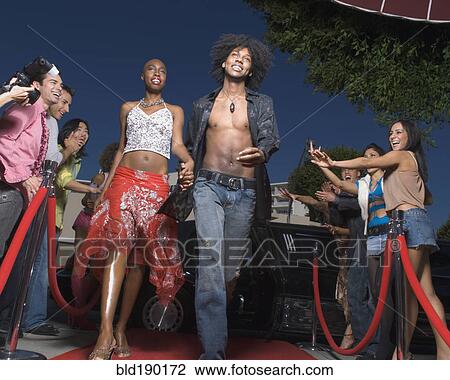 Stock Image - African couple walking on red carpet. Fotosearch