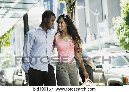 Stock Photo - African couple walking on sidewalk. Fotosearch