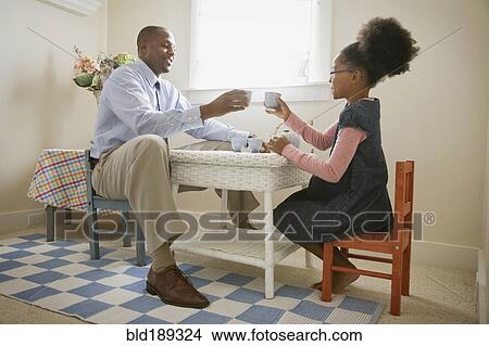 Picture - African father and daughter having tea party. Fotosearch