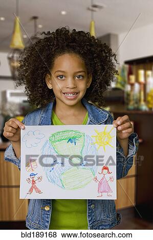 Stock Photo - African girl holding drawing of the Earth. Fotosearch