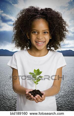 African girl holding seedling in desert View Large Photo Image Stock Image - African girl holding seedling in desert. Fotosearch