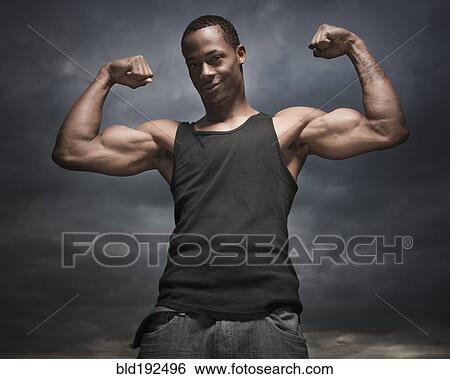 African man flexing arms, storm clouds in distance View Large Photo Image Stock Photograph - African man flexing arms, storm clouds in distance. Fotosearch