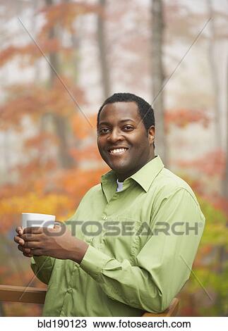 African man holding cup of coffee View Large Photo Image Stock Image - African man holding cup of coffee. Fotosearch