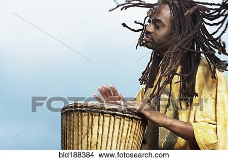 Picture - African man playing drum. Fotosearch