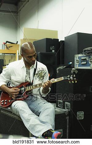Stock Image - African man playing electric guitar. Fotosearch