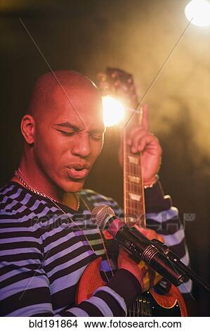 African man singing and playing electric guitar onstage View Large Photo Image Picture - African man singing and playing electric guitar onstage. Fotosearch