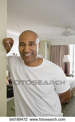 Stock Image - African man smiling in doorway. Fotosearch