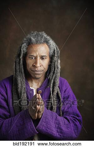 Stock Image - African man with dreadlocks praying. Fotosearch