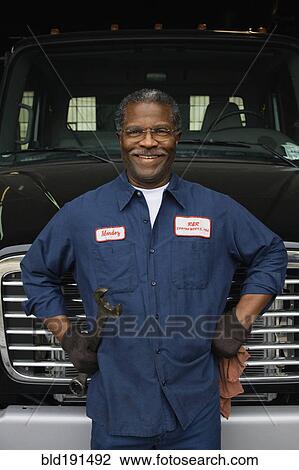 Stock Image - African mechanic standing in front of truck. Fotosearch