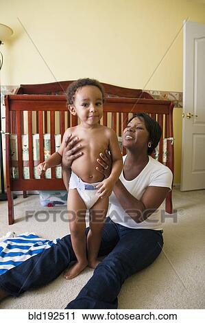 Stock Image - African mother playing with young son. Fotosearch