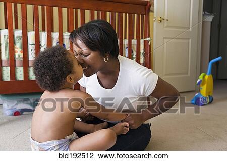 Stock Image - African mother playing with young son. Fotosearch