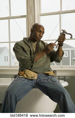 African plumber repairing faucet View Large Photo Image Stock Photo - African plumber repairing faucet. Fotosearch