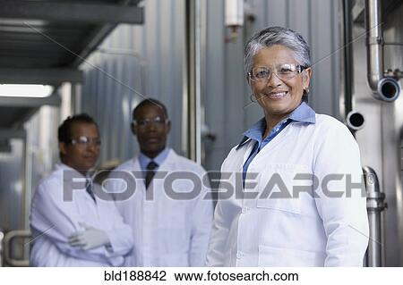 Stock Image - African scientists standing in factory. Fotosearch