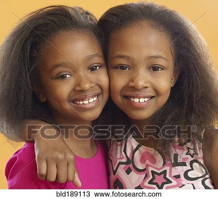 Stock Image - African sisters hugging. Fotosearch